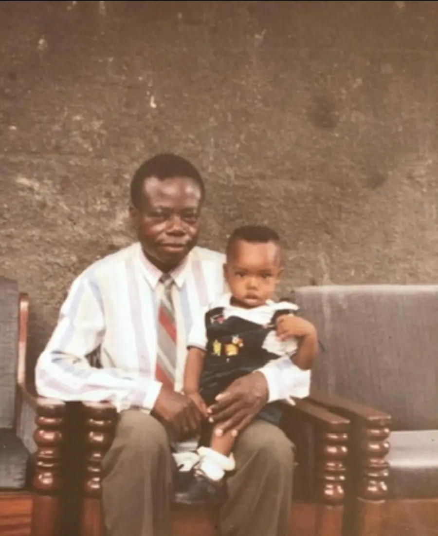 Gaspard Buanga Kadanga tenant son petit-fils sur ses genoux.